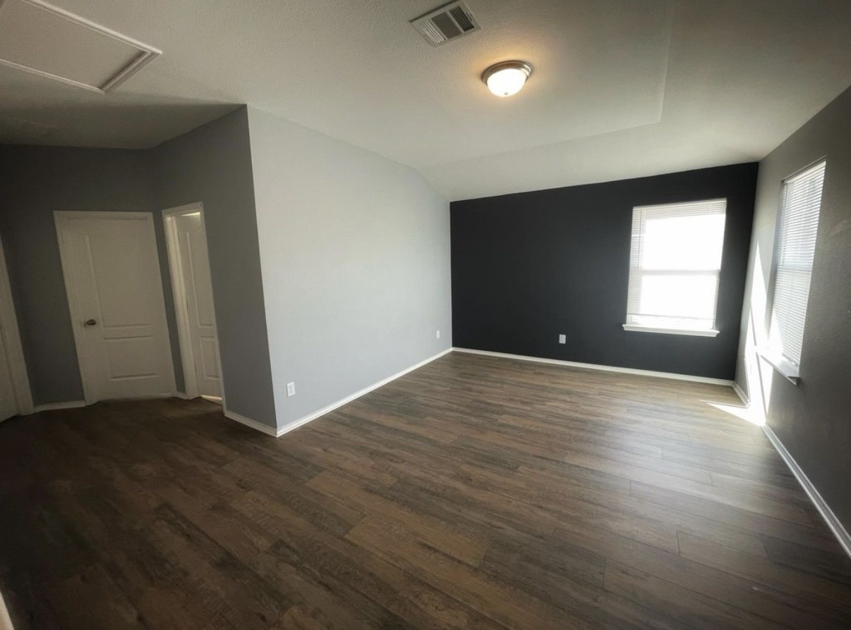 13905 Inaugural Street Manor, TX 78653 - Photo 18 of 26 Empty room featuring dark wood-type flooring and lofted ceiling