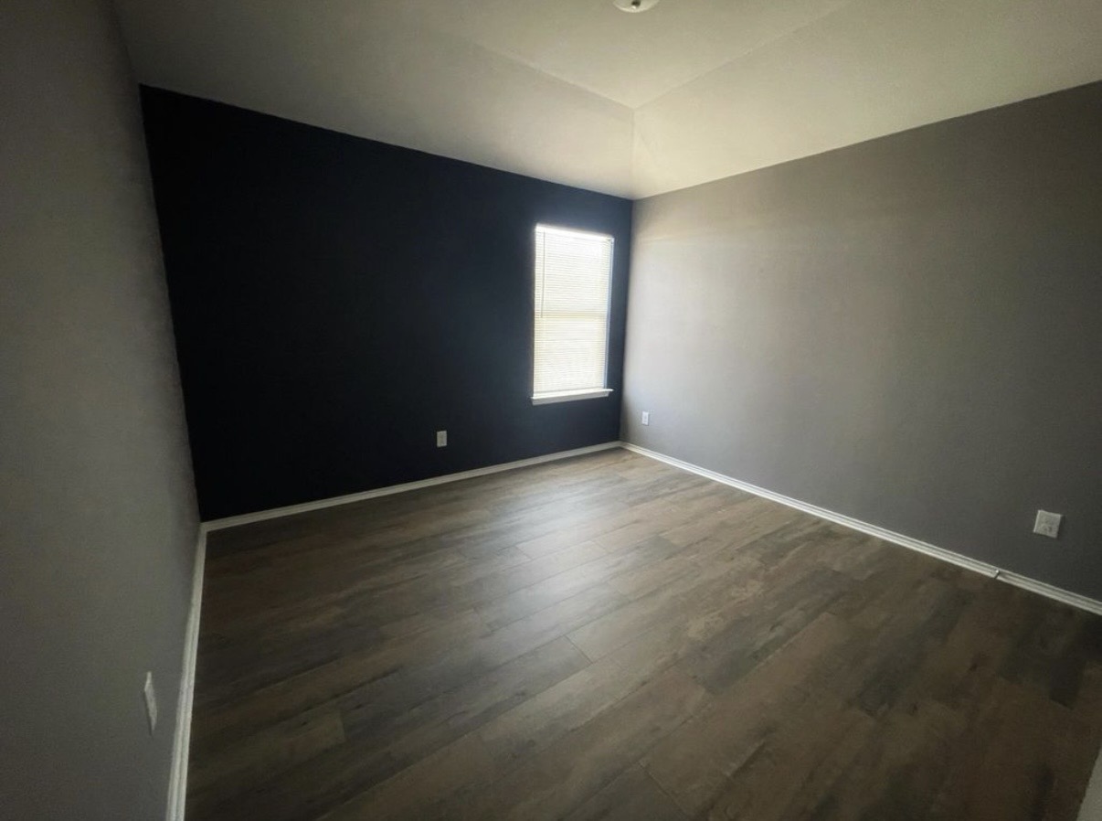 13905 Inaugural Street Manor, TX 78653 - Photo 21 of 26 Spare room with dark wood-type flooring and lofted ceiling
