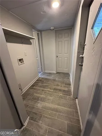 a view of empty room with wooden floor