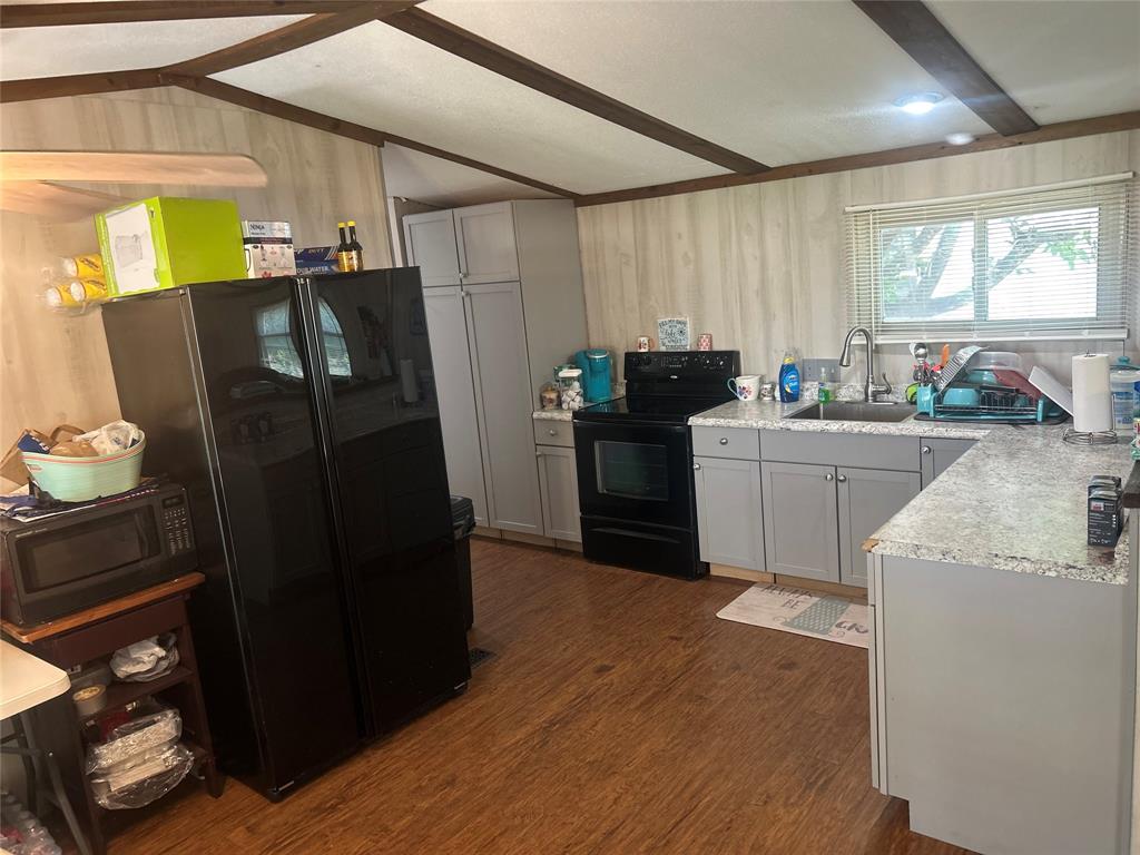 4705 Fox Hollow Road Graham, TX 76450 - Photo 13 of 28 a kitchen with granite countertop a refrigerator and a sink
