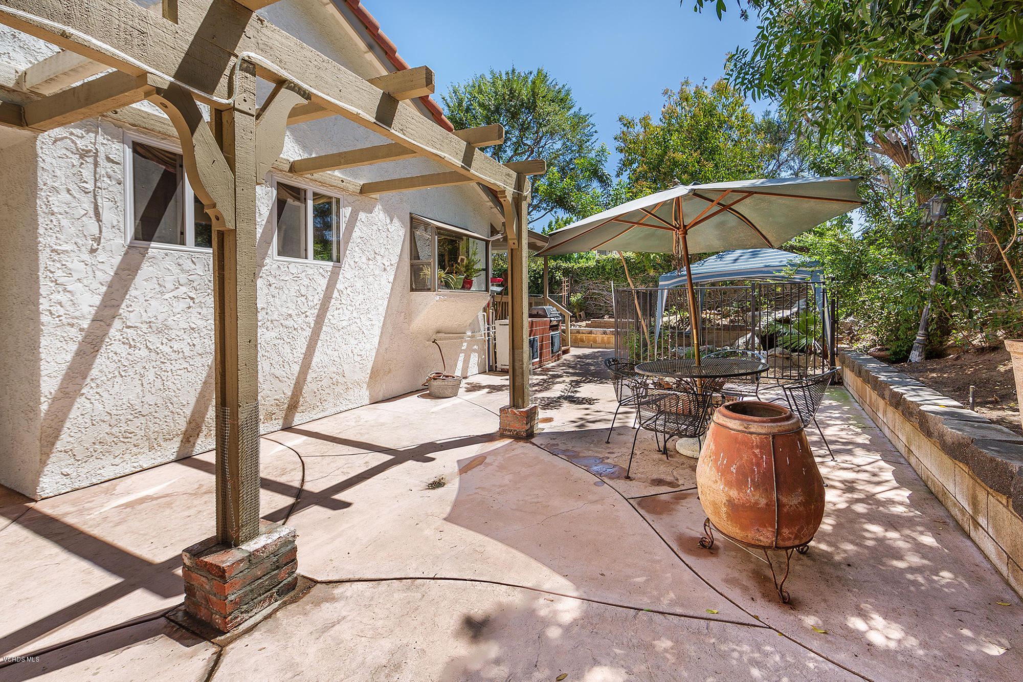 12590 Crystal Ranch Road Moorpark, CA 93021 - Photo 21 of 21 a view of a patio with a dining table and chairs under an umbrella