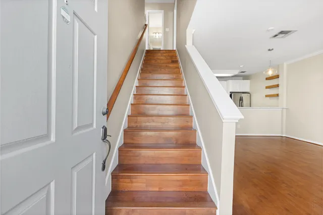 a view of staircase with wooden floor and white walls