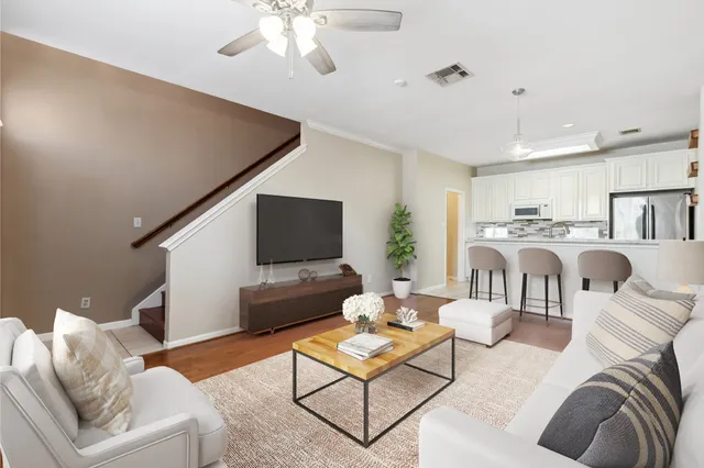 a living room with furniture a flat screen tv and kitchen view