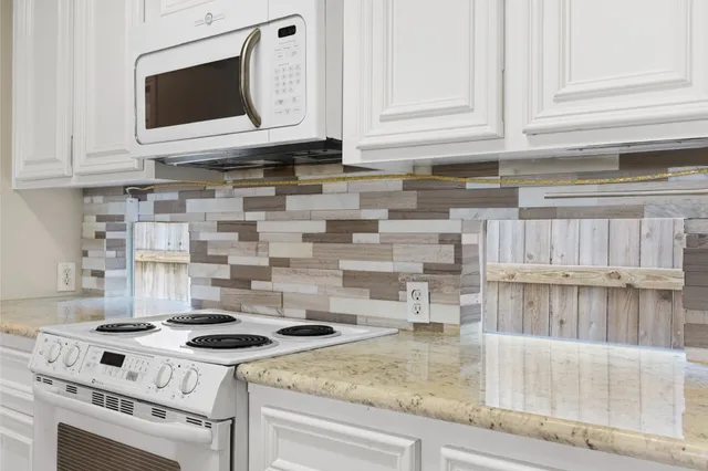 a kitchen with granite countertop a stove and a microwave