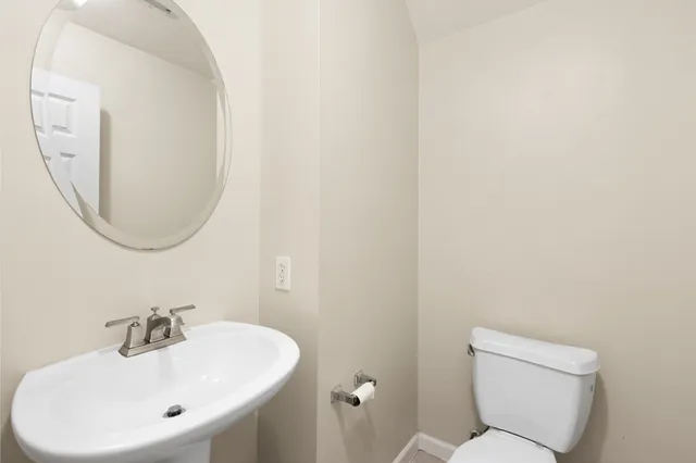 a bathroom with a sink mirror and toilet