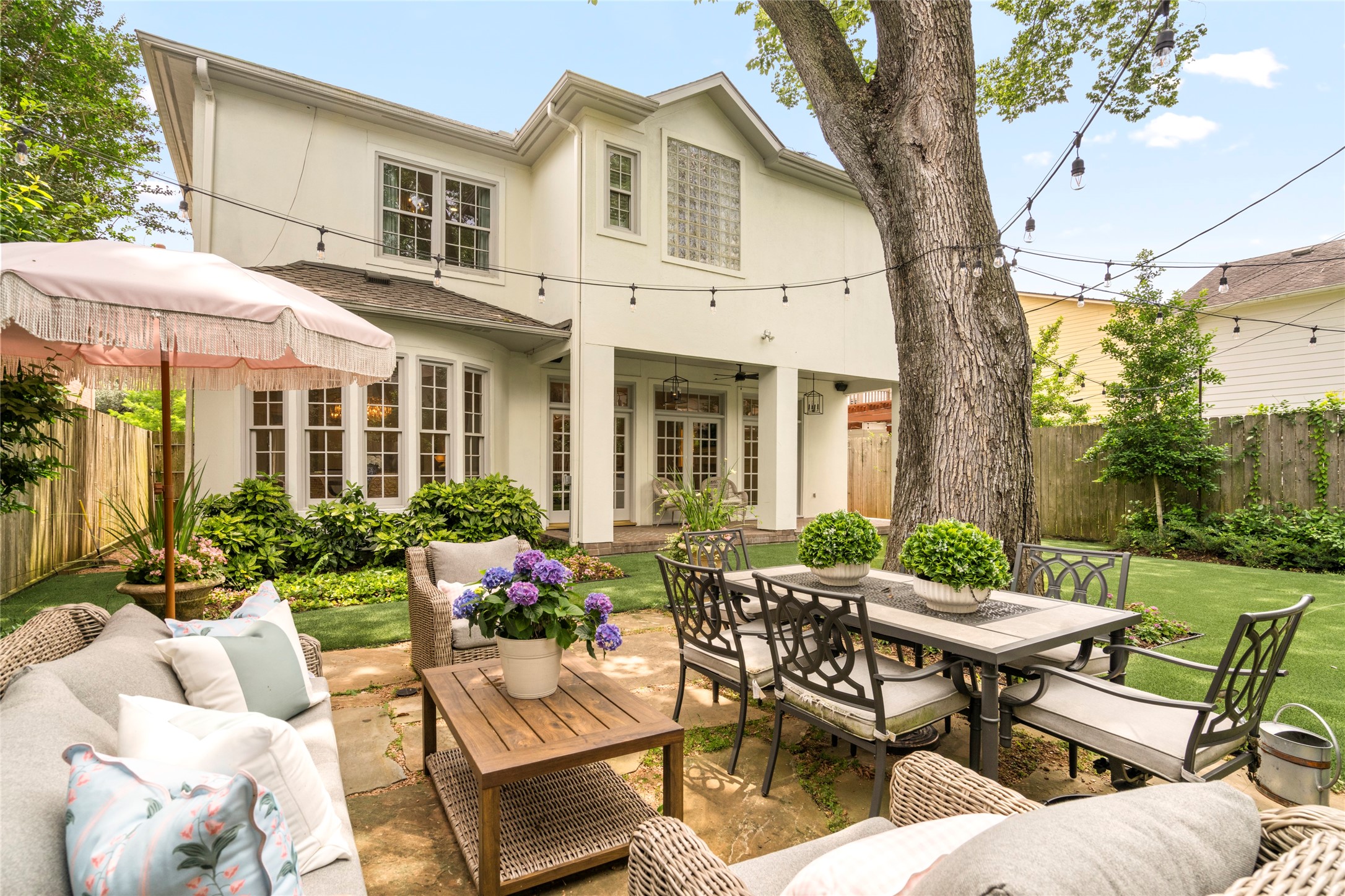 4220 Riley Street West University Place, TX 77005 - Photo 17 of 35 Beautiful outdoor entertaining space complete with an enchanting terrace, magnificent oak tree and turfed yard. This oversized backyard is the perfect place for al fresco dining. Celebrate birthdays, anniversaries, wedding/baby showers reunions and a very large group for mahjong. This space can accommodate at least 60 ladies at 15 four-top tables. Don't miss the bistro lights which will be included in your purchase.