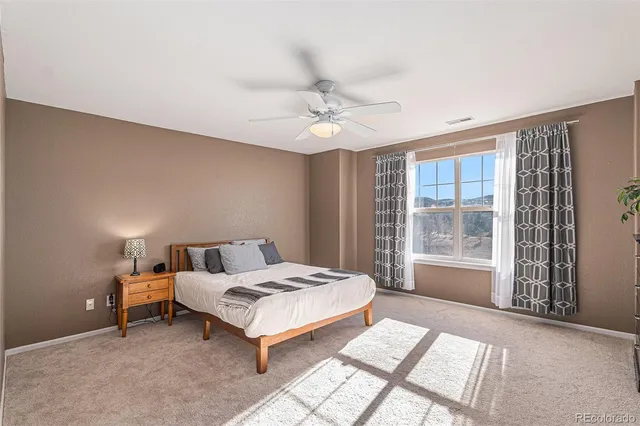 a bedroom with a bed and a large window with outer view