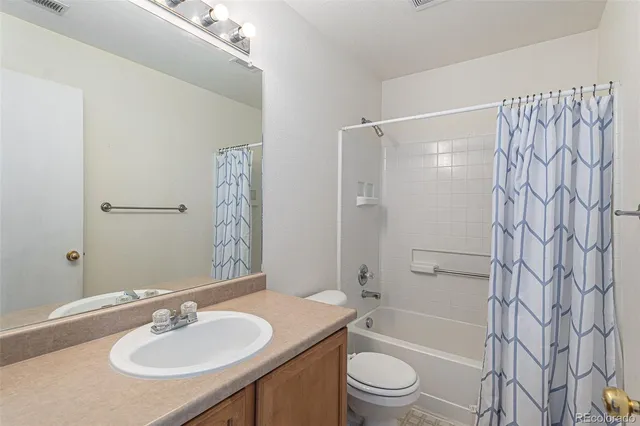 a bathroom with a granite countertop sink toilet a shower and a mirror