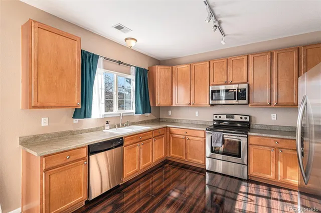 a kitchen with stainless steel appliances granite countertop a stove sink microwave and window
