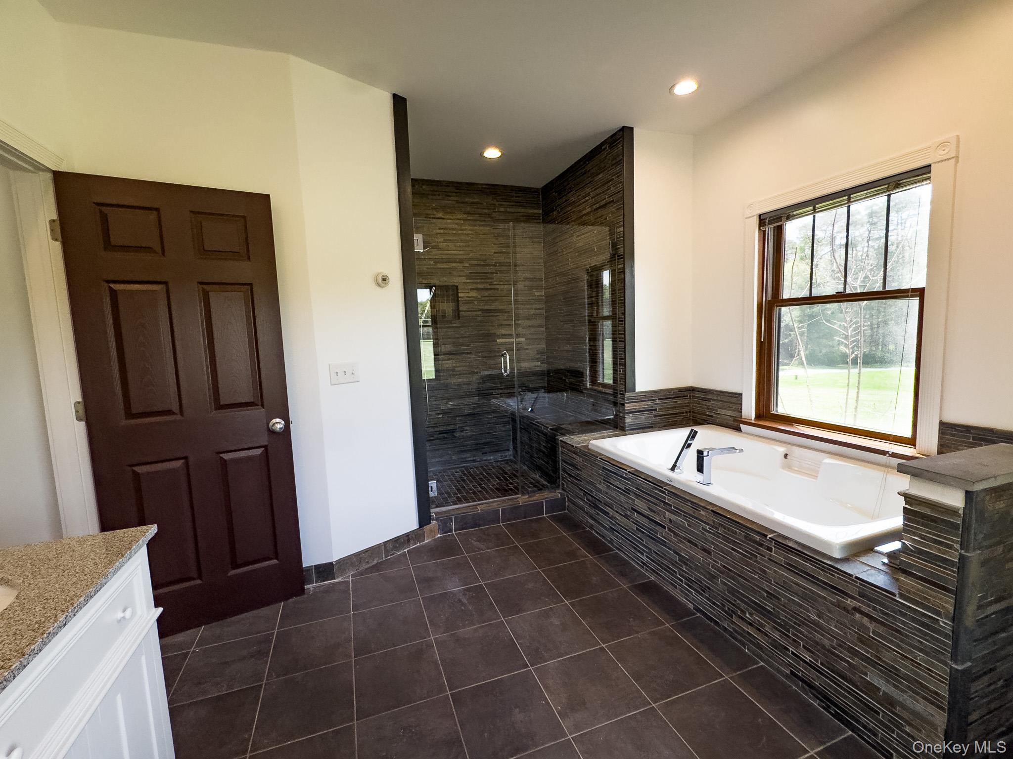58 Deer Meadow Road Bethel, NY 12786 - Photo 20 of 29 a spacious bathroom with a granite countertop tub sink and mirror