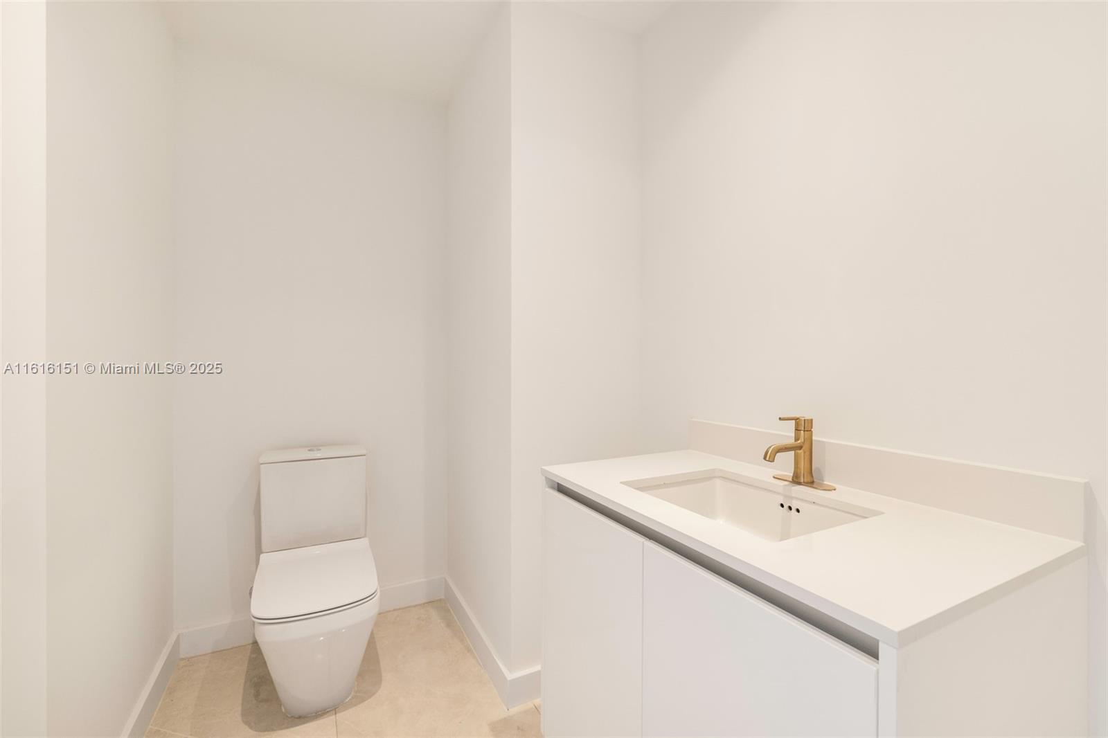 2678 Tigertail Avenue, Unit 1104 Miami, FL 33133 - Photo 28 of 65 a bathroom with a sink a toilet and a mirror