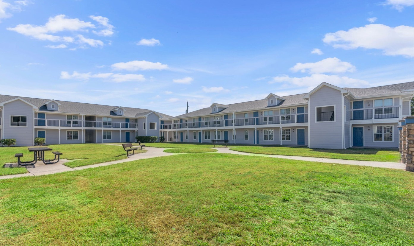 8210 Bauman Road, Unit 40 Houston, TX 77022 - Photo 8 of 10 a view of a building with a big yard and a large tree