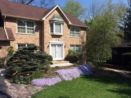 a front view of a house with a garden