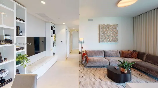 a living room with furniture potted plant and a flat screen tv