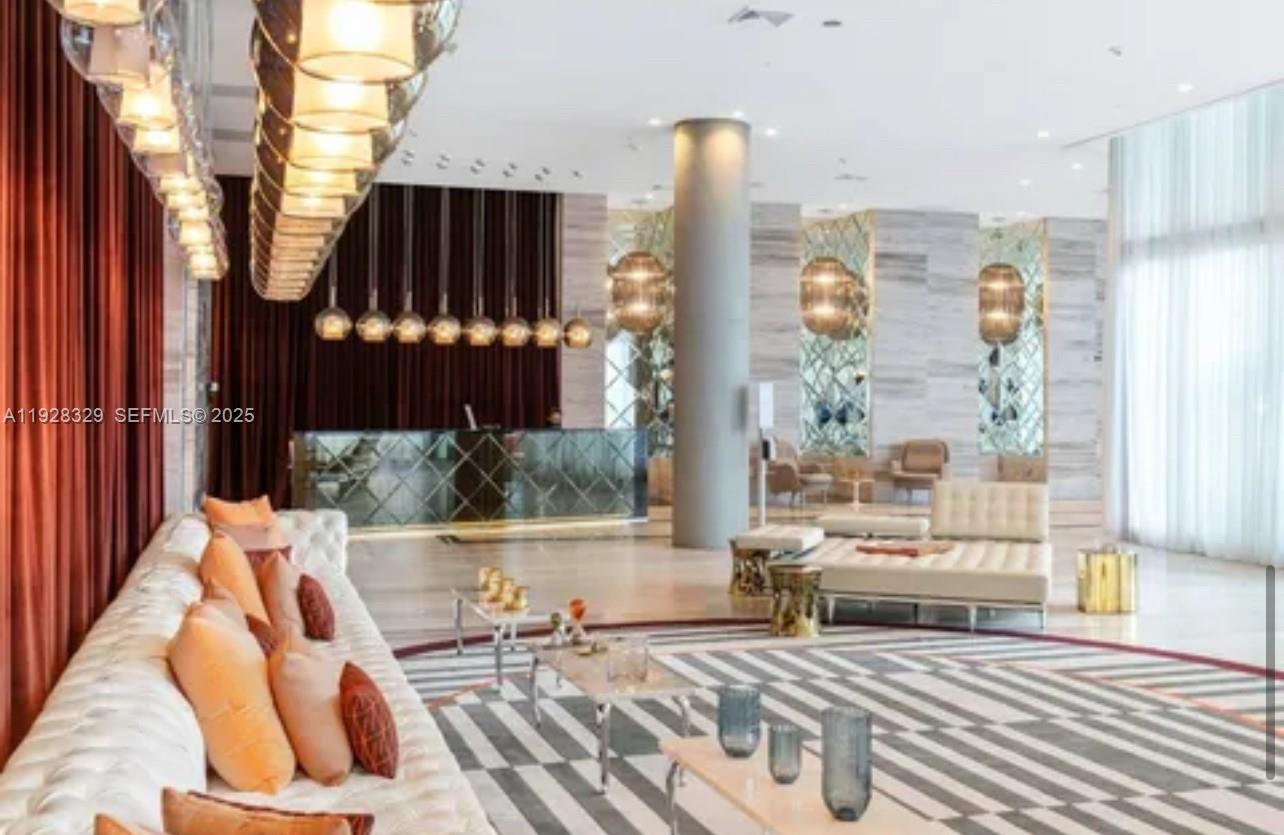 2000 Metropica Way, Unit 1701 Sunrise, FL 33323 - Photo 27 of 32 a living room filled with furniture and a floor to ceiling window