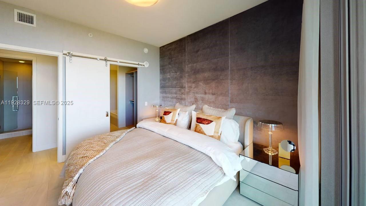 2000 Metropica Way, Unit 1701 Sunrise, FL 33323 - Photo 5 of 32 a bedroom with a bed and a walk in closet