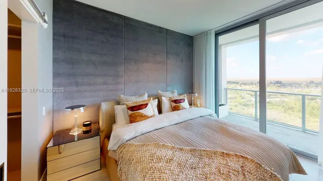 a bedroom with a bed and large windows