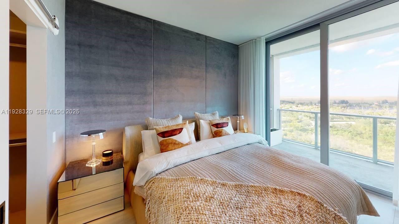 2000 Metropica Way, Unit 1701 Sunrise, FL 33323 - Photo 6 of 32 a bedroom with a bed and large windows