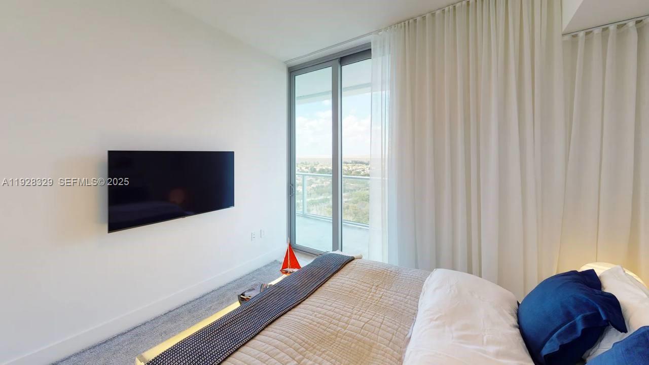 2000 Metropica Way, Unit 1701 Sunrise, FL 33323 - Photo 9 of 32 a bedroom with a bed and a flat screen tv