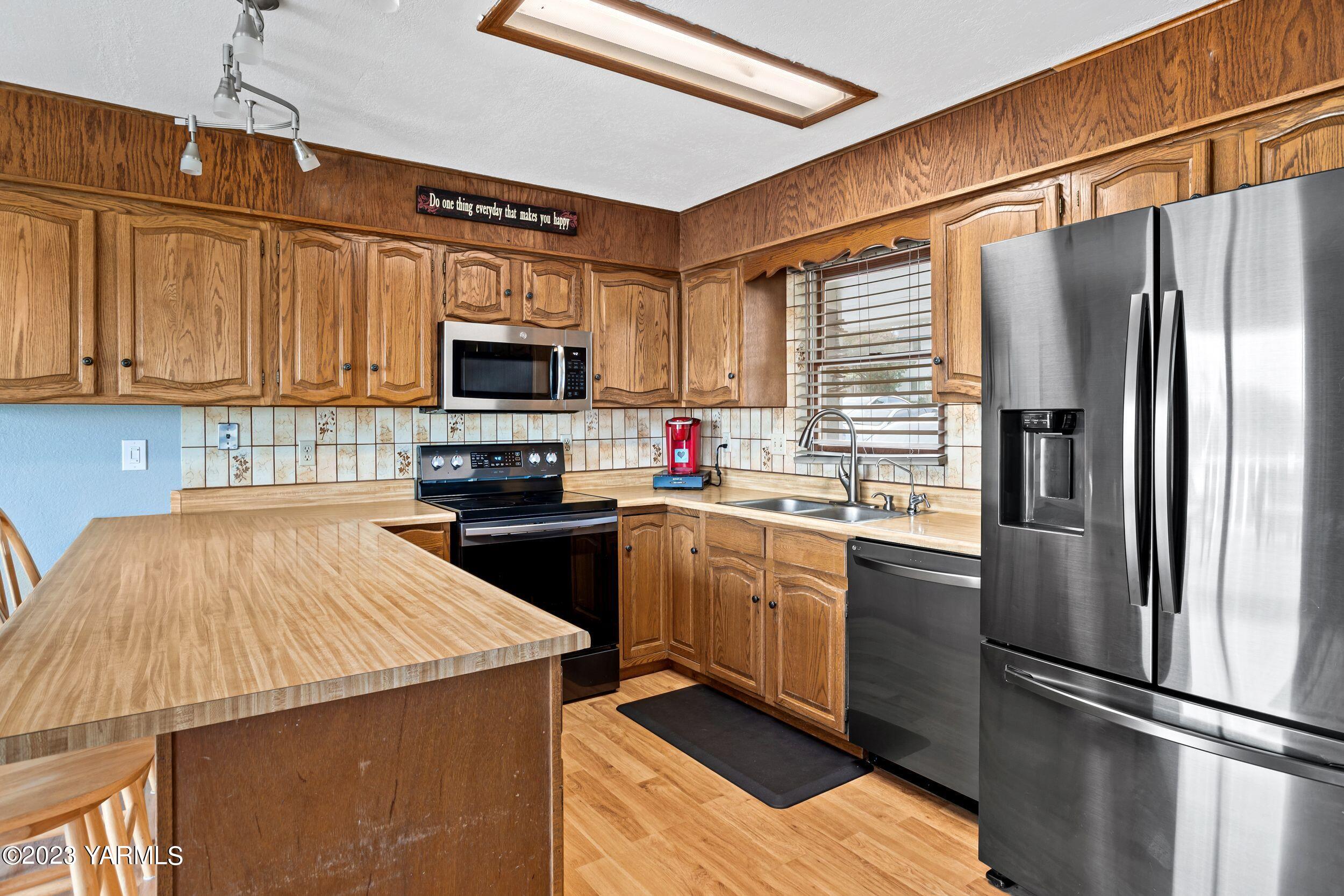 11902 Marble Road Yakima, WA 98908 - Photo 9 of 29 a kitchen with granite countertop a refrigerator and a stove top oven