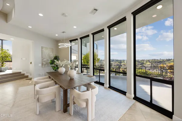 a living room with couches and a large window with garden view