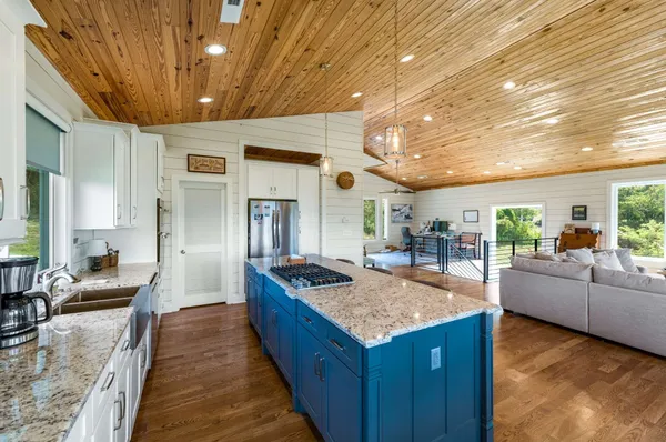 a view of living room kitchen with granite countertop stainless steel appliances and living room view