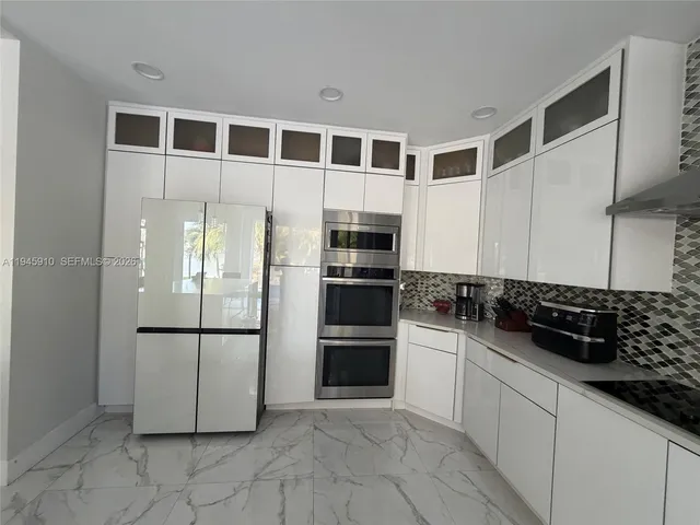 a kitchen with stainless steel appliances granite countertop a refrigerator and a stove