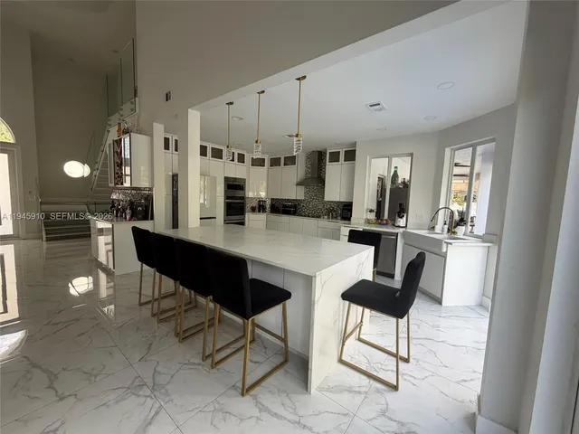 a large kitchen with kitchen island granite countertop a large counter top and stainless steel appliances