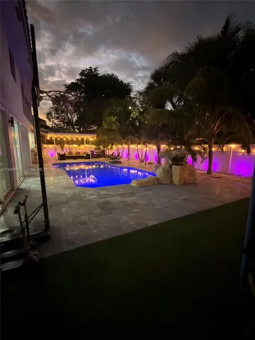 a view of a pool with an outdoor space and seating area