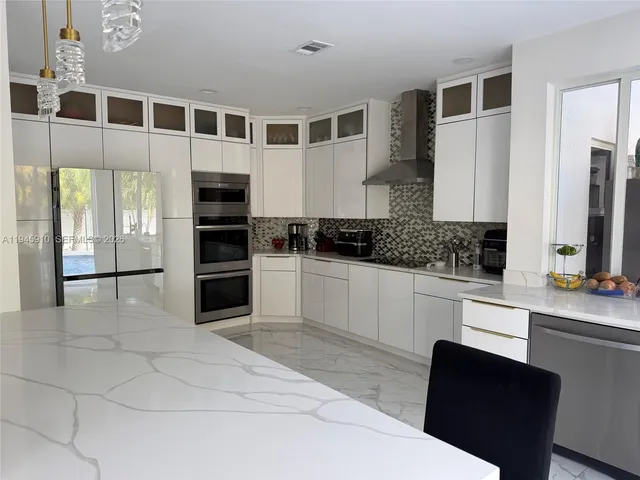 a kitchen with stainless steel appliances a refrigerator sink and cabinets
