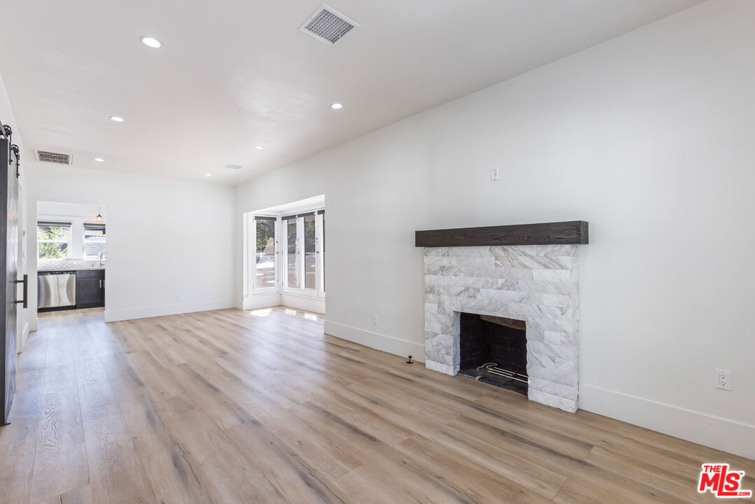 150 Dearborn Street Pasadena, CA 91103 - Photo 2 of 4 a view of an empty room with wooden floor fireplace and a window