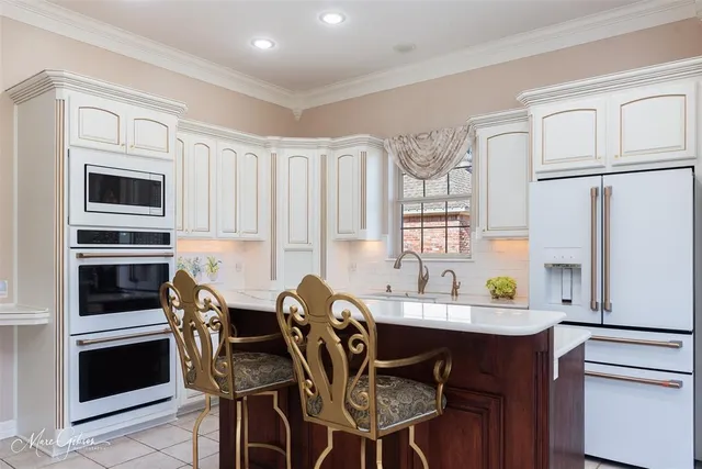 a kitchen with stainless steel appliances a table chairs and a refrigerator