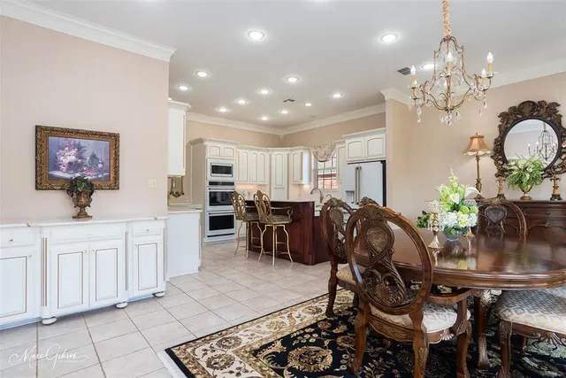 a very nice looking dining room with kitchen island granite countertop a table chairs and a chandelier