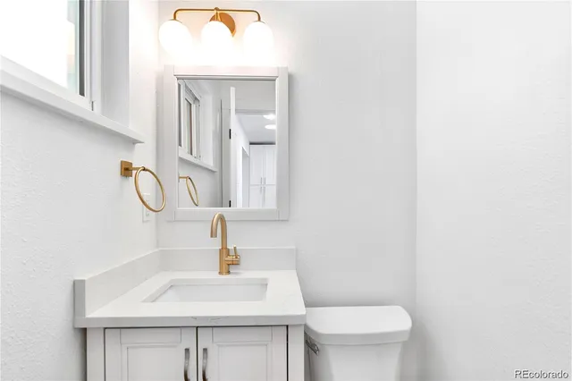a bathroom with a sink a toilet and mirror