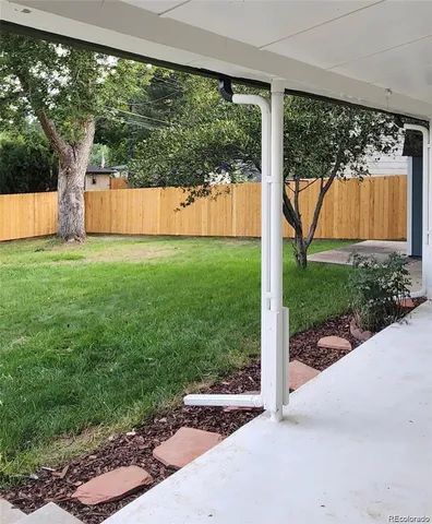 a view of backyard with large tree and a yard