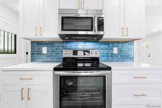 a kitchen with stainless steel appliances granite countertop a stove and a microwave