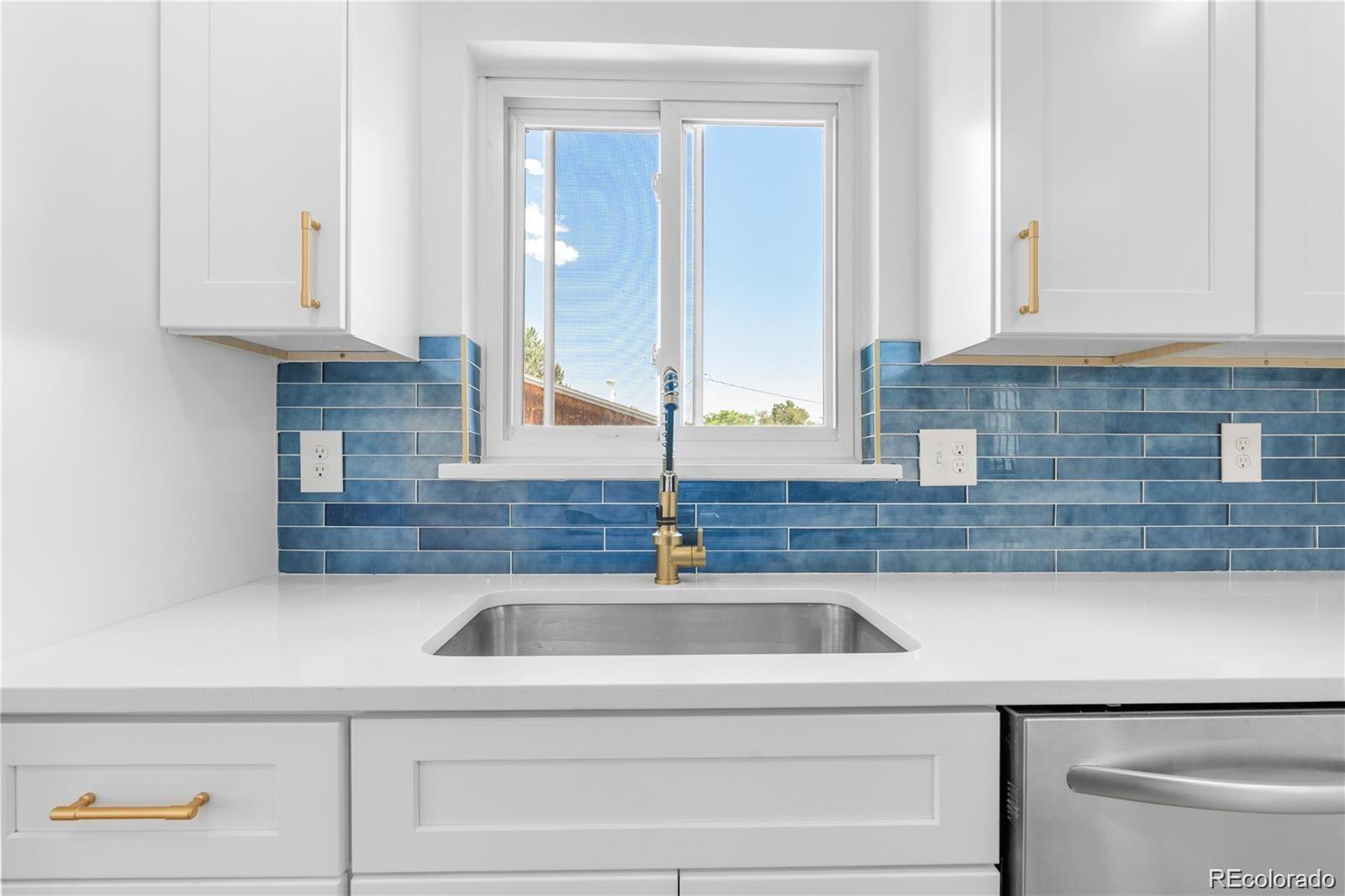 6500 West 32nd Avenue Wheat Ridge, CO 80033 - Photo 7 of 39 a kitchen with stainless steel appliances granite countertop a sink and a white cabinets