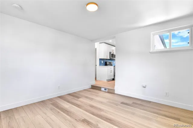 a view of a room with wooden floor and white walls