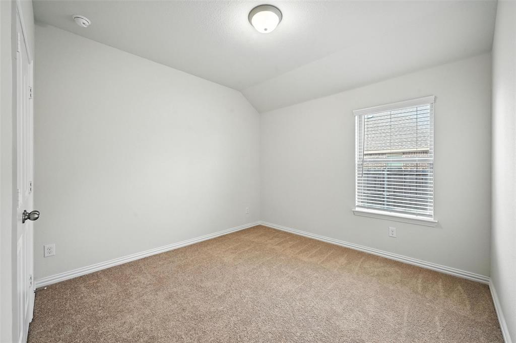 5 Pheasant Run Sanger, TX 76266 - Photo 14 of 27 Spare room with light colored carpet and lofted ceiling