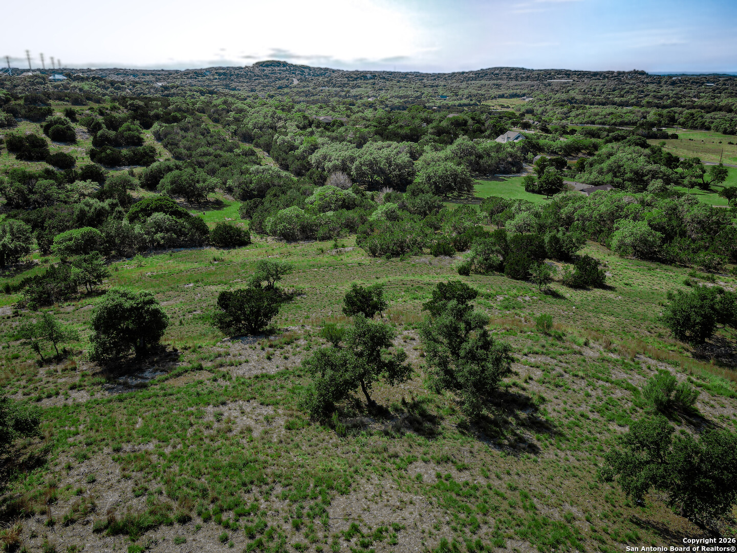 818 Lovett Rdg Road Bulverde, TX 78163 - Photo 2 of 12 a view of a lush green forest with trees and some houses