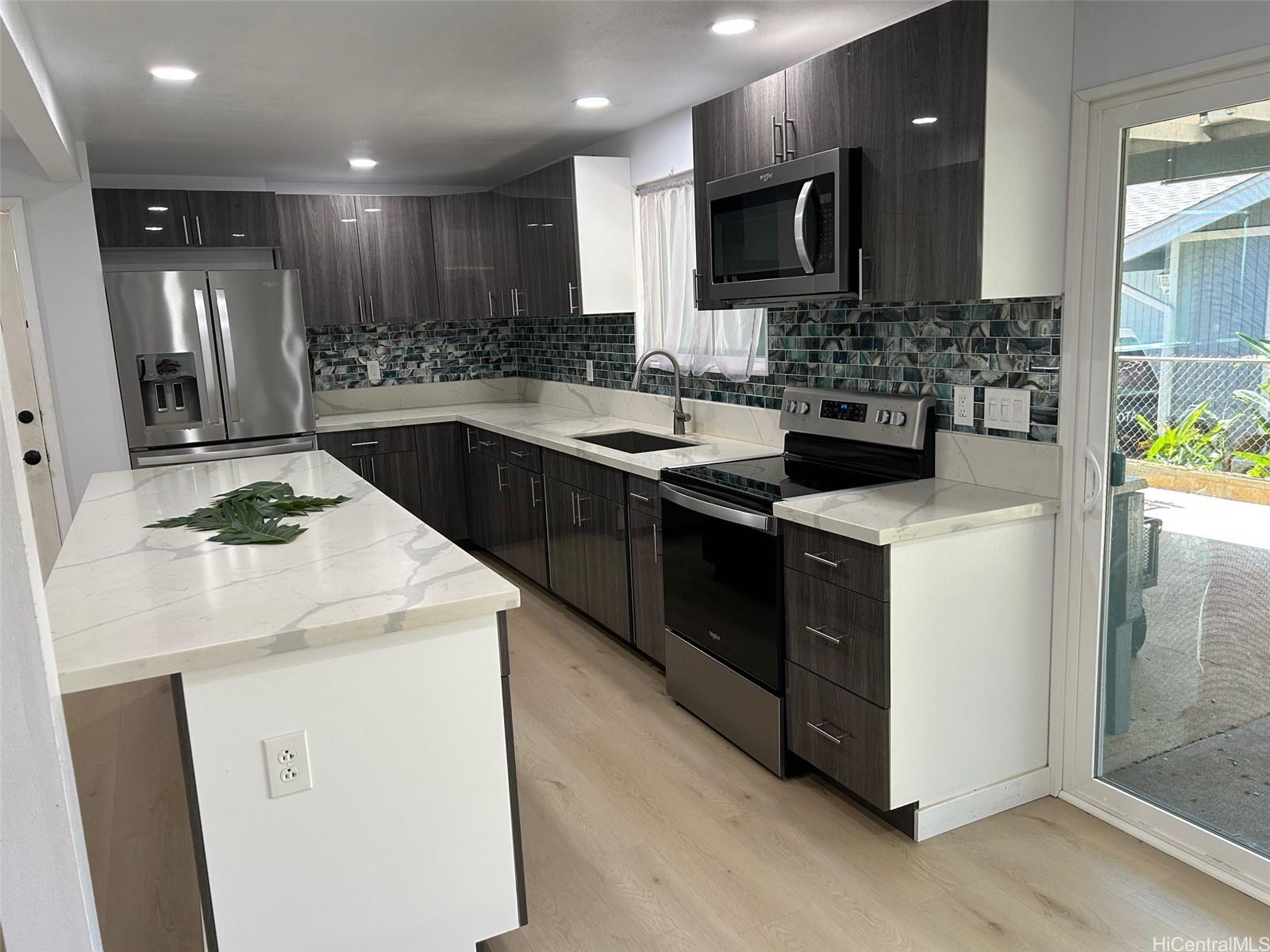 84-116 Kapakai Place Waianae, HI 96792 - Photo 2 of 14 a kitchen with stainless steel appliances kitchen island a sink stove and refrigerator