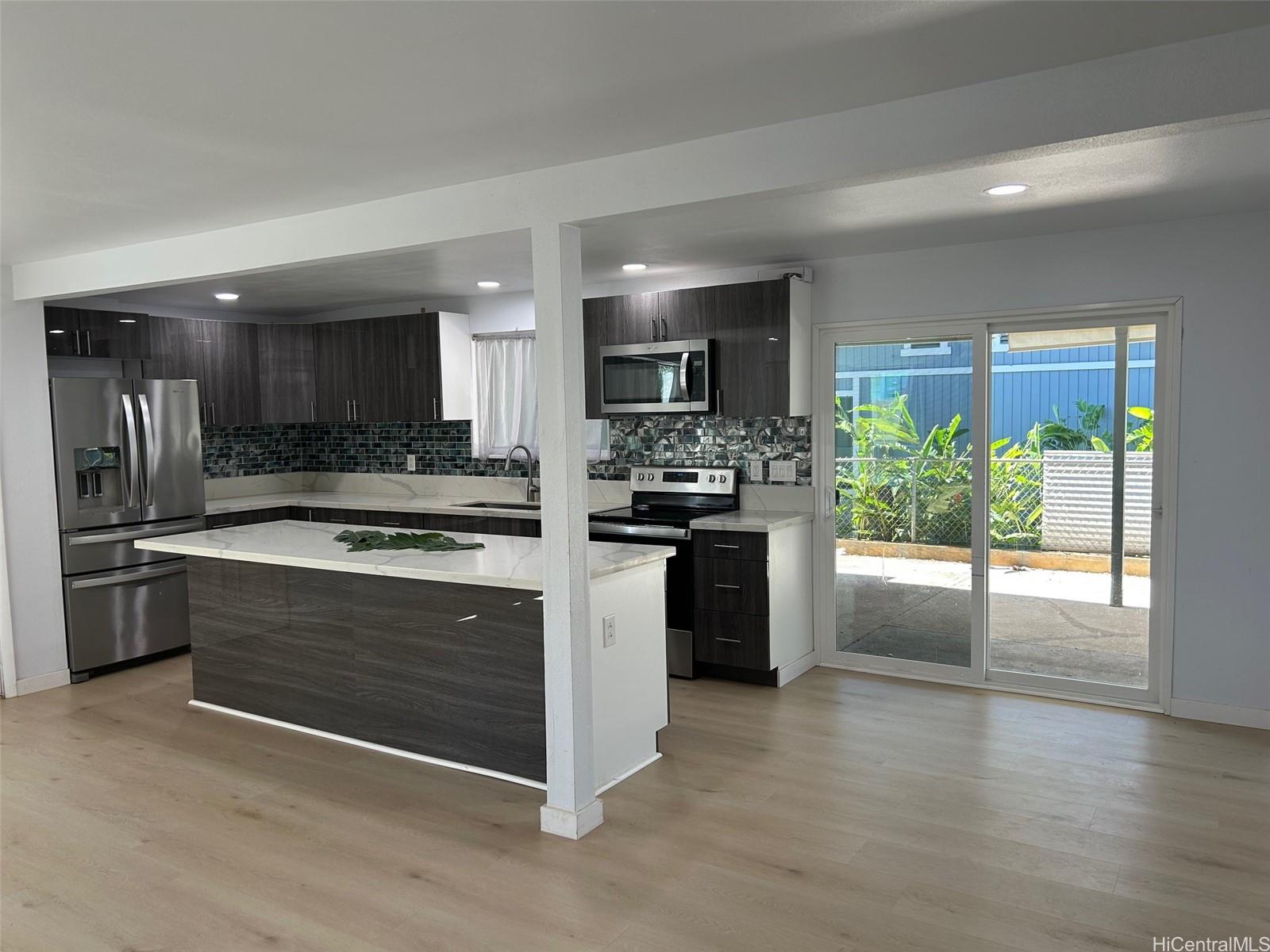 84-116 Kapakai Place Waianae, HI 96792 - Photo 3 of 14 a large kitchen with stainless steel appliances granite countertop a stove a sink and a refrigerator