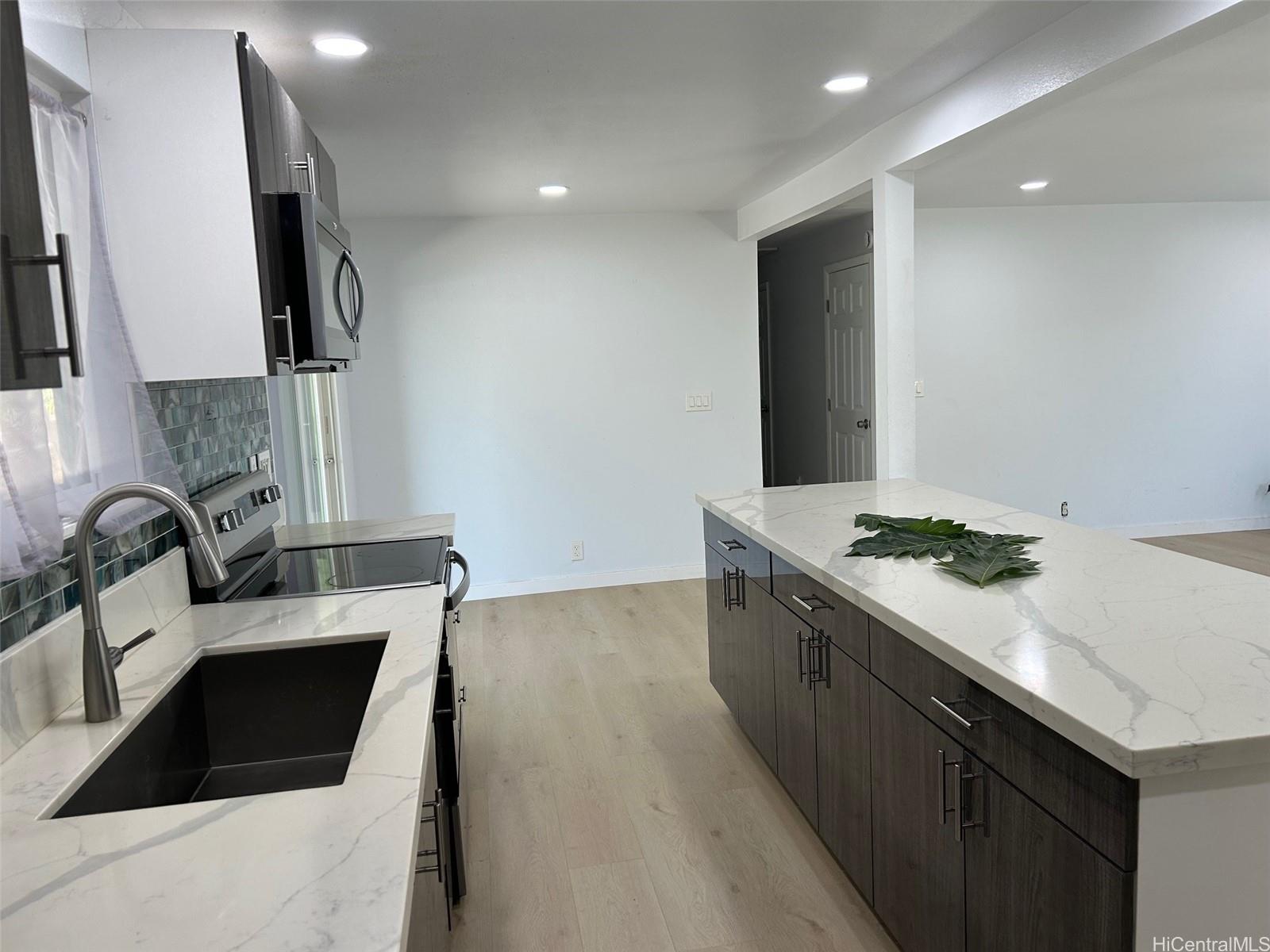84-116 Kapakai Place Waianae, HI 96792 - Photo 5 of 14 a kitchen with stainless steel appliances granite countertop a sink stove and refrigerator