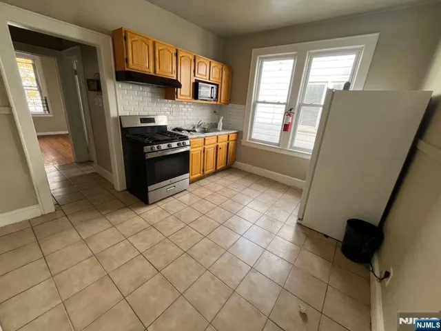 a kitchen with stainless steel appliances a sink a stove top oven a counter space and a window