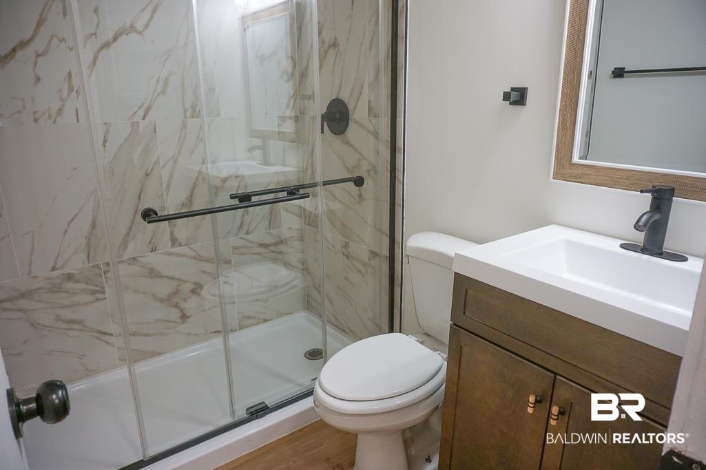 4734 Kirkwell Drive Mobile, AL 36619 - Photo 14 of 18 Bathroom featuring vanity, toilet, and a shower with shower door