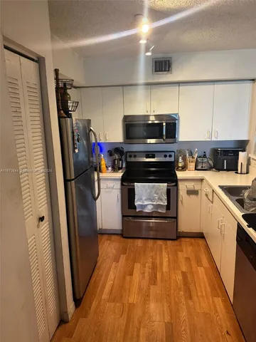 a kitchen with appliances a sink and cabinets
