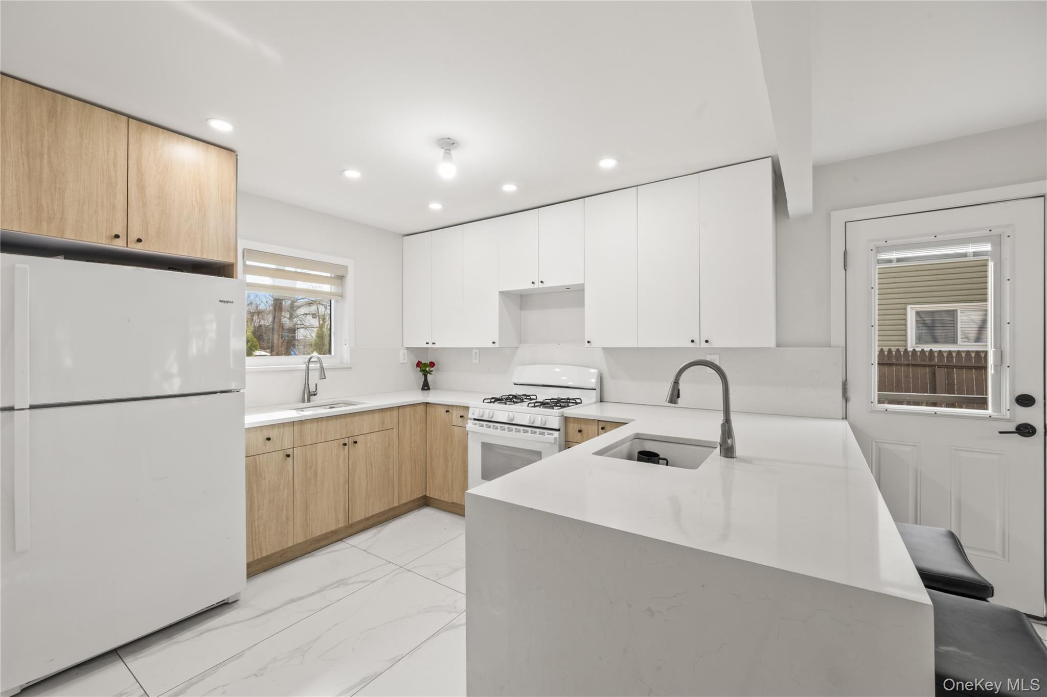 10 Sneden Court Spring Valley, NY 10977 - Photo 14 of 42 a kitchen with sink a refrigerator and white cabinets with wooden floor
