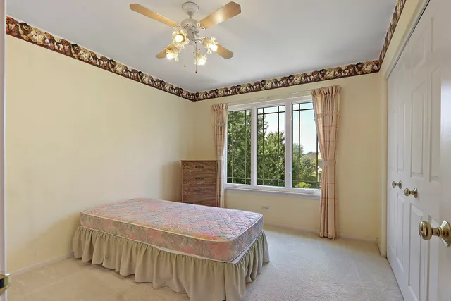 a spacious bedroom with a bed and a chandelier