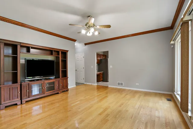 a view of a livingroom with wooden floor and a ceiling fan