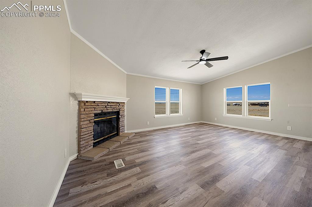 8160 Edison Road Yoder, CO 80864 - Photo 12 of 42 a view of empty room with a fireplace and wooden floor